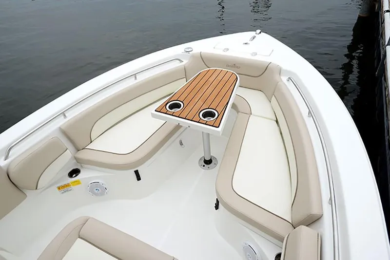 Slide: The Image of 2023 NauticStar 2302 Legacy boat with cushioned seating and wooden table. - 20