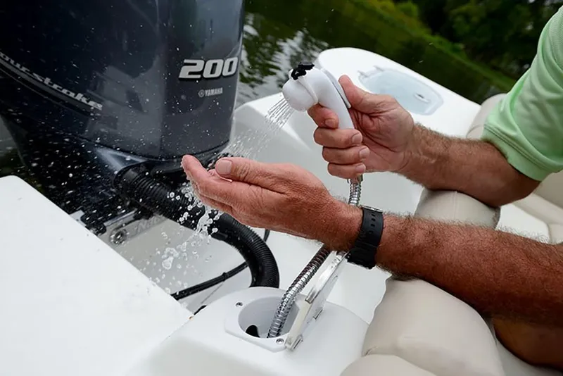 Slide: The Image of Man using a hand shower on a 2023 NauticStar 2302 Legacy boat. - 28