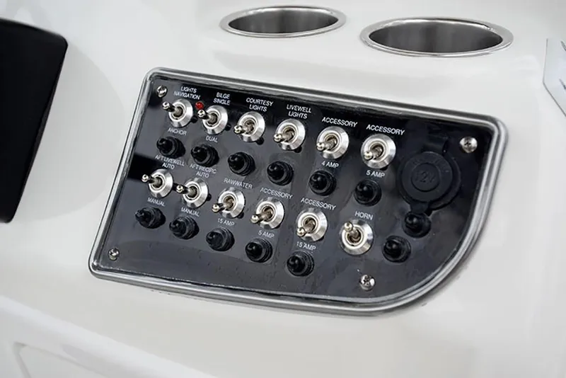 Slide: The Image of Control panel of a 2023 NauticStar 2302 Legacy boat with various switches and cup holders. - 34