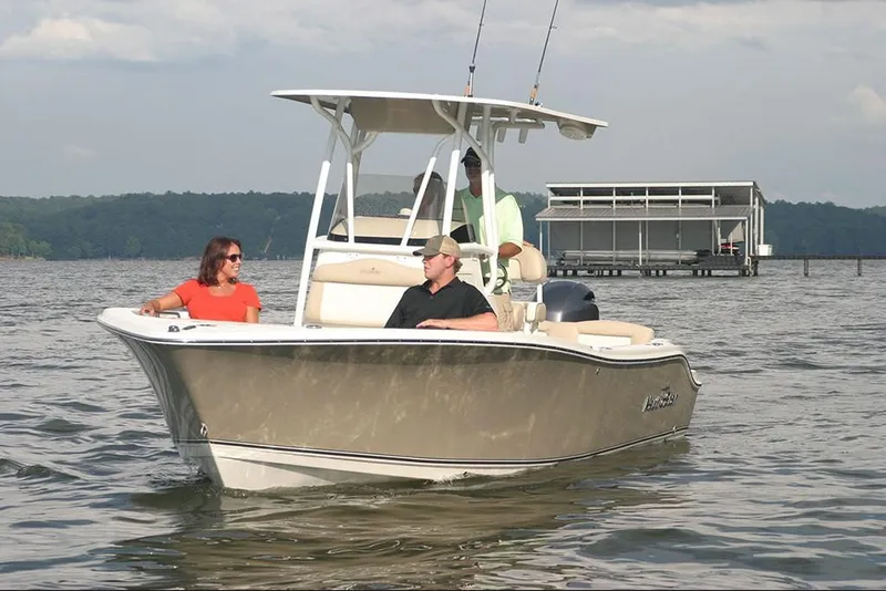 Slide: The Image of 2023 NauticStar 2302 Legacy boat on water with three people onboard. - 9