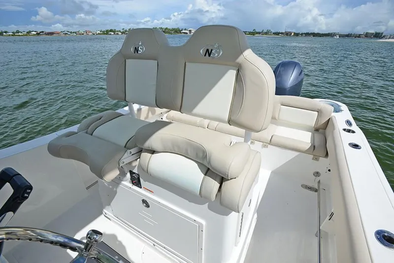 Slide: The Image of 2023 NauticStar 2602 Legacy boat with dual captain's chairs on a calm water backdrop. - 21