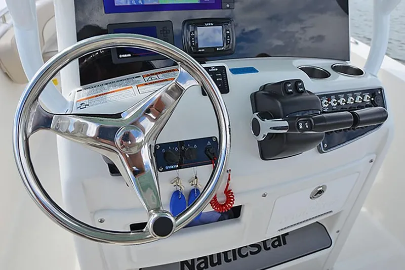 Slide: The Image of 2023 NauticStar 2602 Legacy boat helm with steering wheel and control panel. - 22
