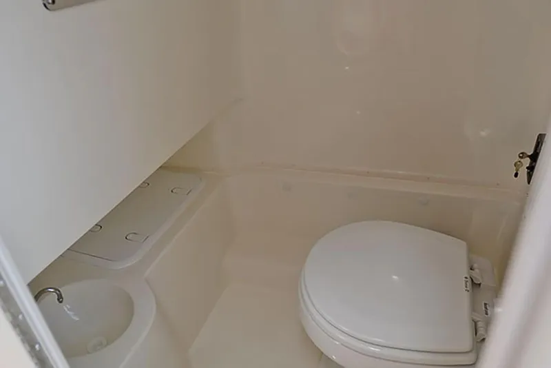 Slide: The Image of 2023 NauticStar 2602 Legacy boat bathroom with toilet and sink. - 27