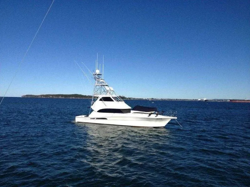 Slide: The Image of 2004 Riviera 58 Enclosed Flybridge yacht on open water. - 1