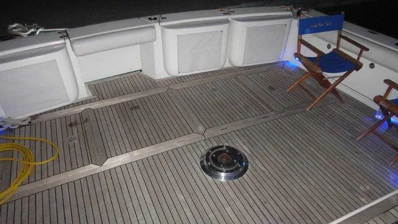 Slide: The Image of 2004 Riviera 58 Enclosed Flybridge deck with wooden flooring and seating. - 10