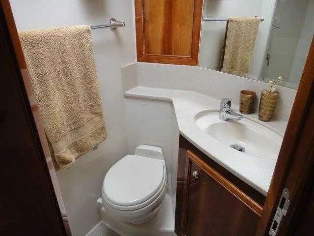 Slide: The Image of 2004 Riviera 58 Enclosed Flybridge bathroom with sink, toilet, and mirror. - 36