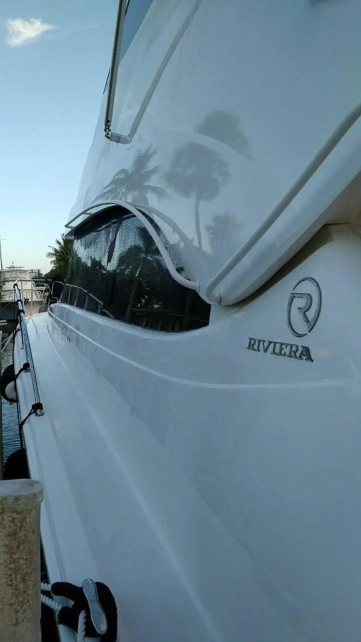 Slide: The Image of 2004 Riviera 58 Enclosed Flybridge yacht side view with logo. - 4