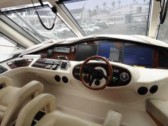Slide: The Image of 2004 Riviera 58 Enclosed Flybridge yacht helm with advanced navigation systems and luxurious seating. - 41