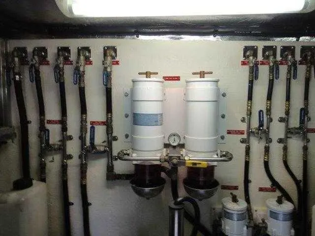 Slide: The Image of Engine room of 2004 Riviera 58 Enclosed Flybridge with fuel filters and valves. - 46