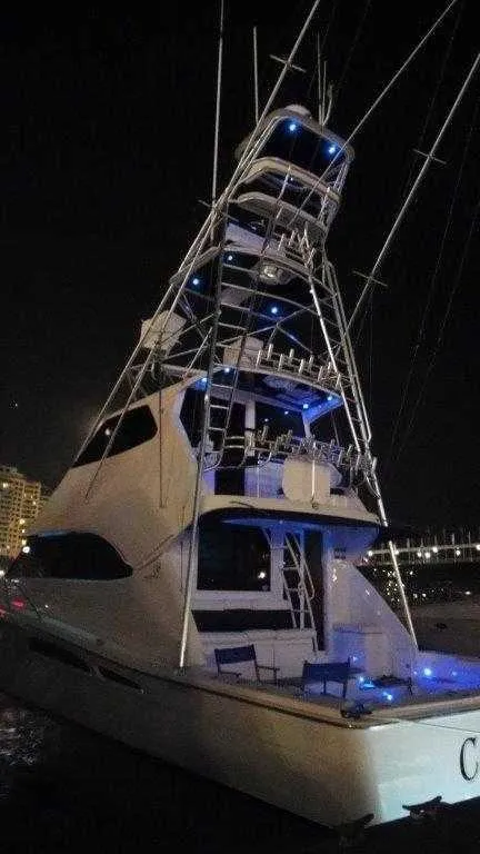 Slide: The Image of 2004 Riviera 58 Enclosed Flybridge yacht illuminated at night. - 6