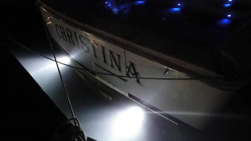 Slide: The Image of 2004 Riviera 58 Enclosed Flybridge yacht Christina illuminated at night. - 8