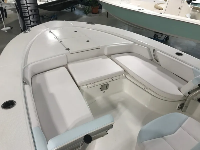 Slide: The Image of 2024 Robalo 246 Cayman Sky Deck boat interior with white cushioned seating. - 8