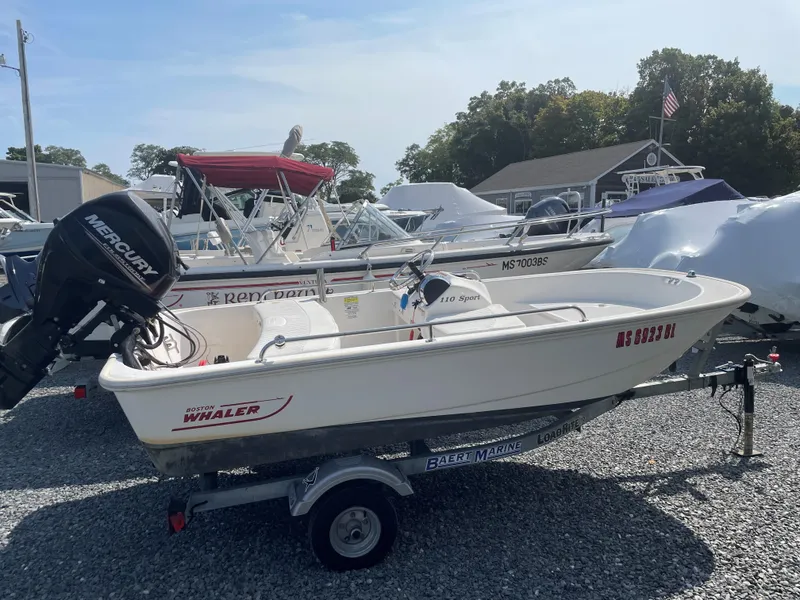 Slide: The Image of 2016 Boston Whaler 110 Sport boat on trailer, parked in marina. - 0
