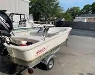 Slide: The Image of 2016 Boston Whaler 110 Sport boat on trailer, parked outdoors. - 11