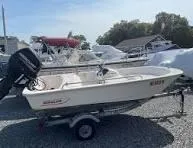 Slide: The Image of 2016 Boston Whaler 110 Sport boat on trailer in marina setting. - 12