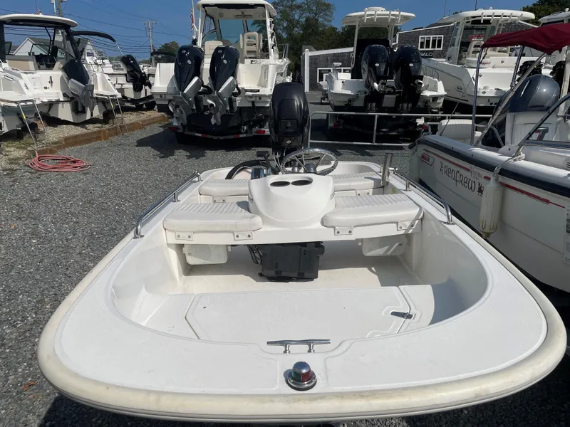 Slide: The Image of 2016 Boston Whaler 110 Sport boat in a marina, surrounded by other vessels. - 2
