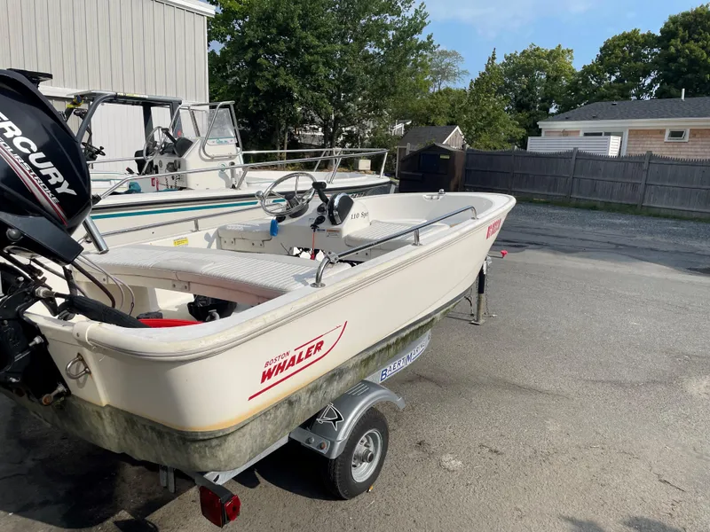 Slide: The Image of 2016 Boston Whaler 110 Sport boat on trailer, parked outdoors. - 7