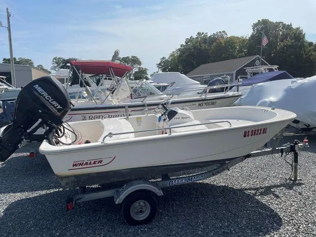 Slide: The Image of 2016 Boston Whaler 110 Sport boat on trailer in marina setting. - 9