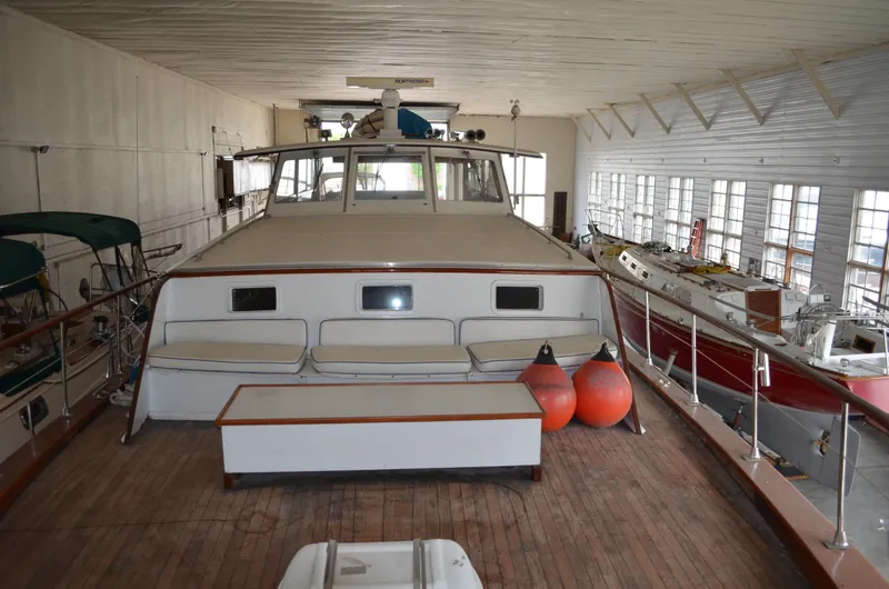 Slide: The Image of 1971 Matthews 56 Motor Yacht in indoor storage, showcasing deck and seating area. - 29