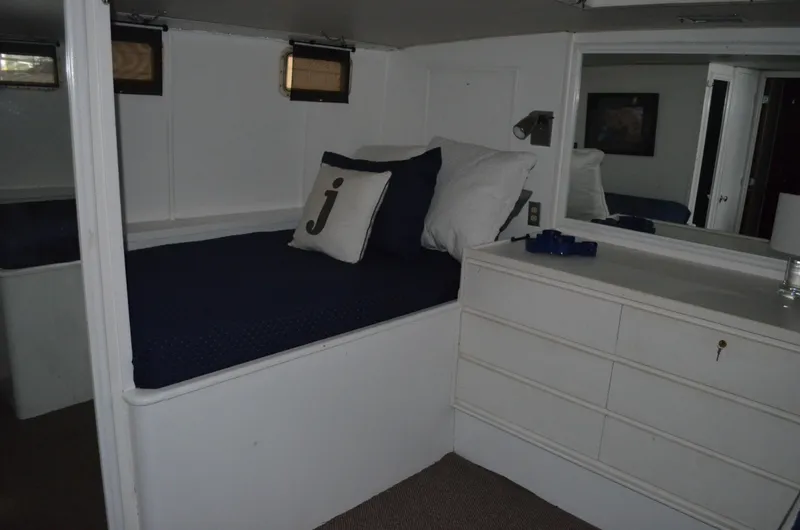 Slide: The Image of 1971 Matthews 56 Motor Yacht cabin with bed, dresser, and nautical decor. - 31