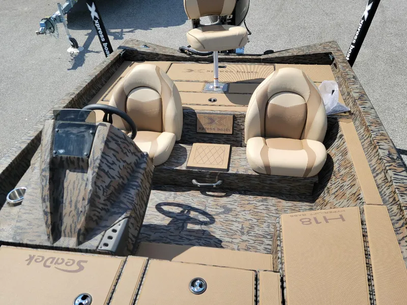 Slide: The Image of 2025 Xpress H20 Bass boat interior with beige seats and camo design. - 3