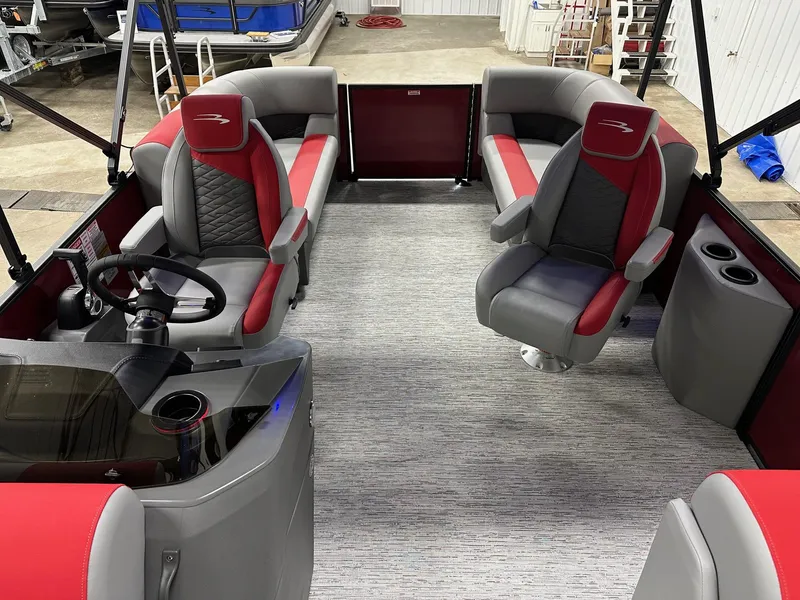Slide: The Image of 2025 Bennington 21 SSR Quad Bench interior with red and gray seating, steering console, and cup holders. - 13