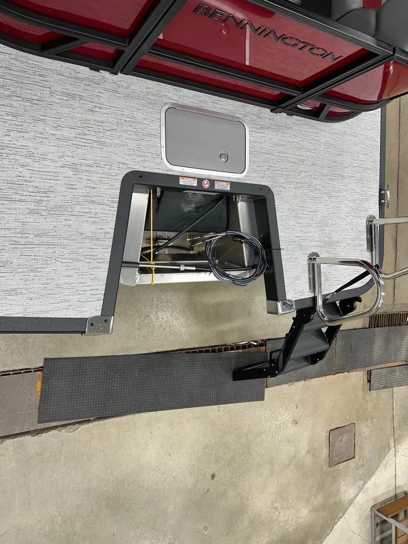 Slide: The Image of 2025 Bennington 21 SSR Quad Bench boat interior with storage compartment and ladder. - 16