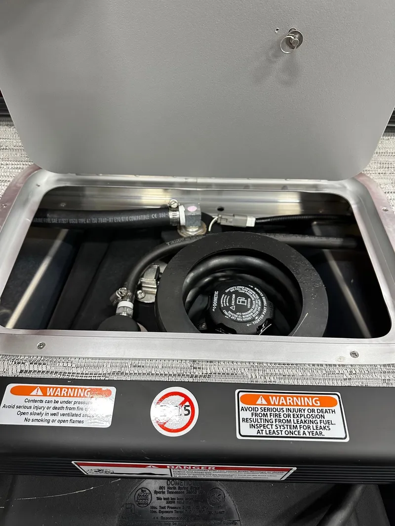 Slide: The Image of Open engine compartment of 2025 Bennington 21 SSR Quad Bench with warning labels visible. - 17