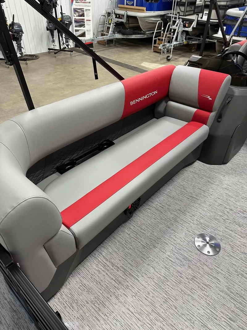 Slide: The Image of 2025 Bennington 21 SSR Quad Bench, red and gray seating in showroom. - 25