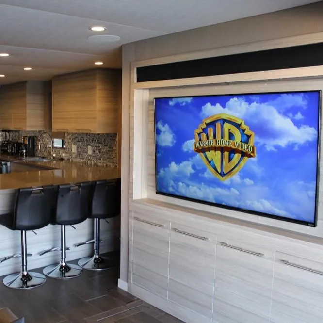Slide: The Image of Modern kitchen with bar stools and large TV displaying Warner Home Video logo. - 12