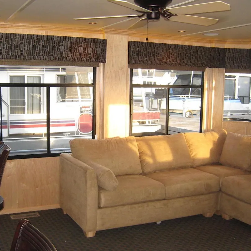 Slide: The Image of Interior of 2009 Sumerset Stargazer Trip 10 houseboat with beige sofa and large windows. - 10