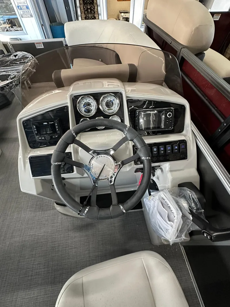 Slide: The Image of 2025 Sylvan Mirage 8520 CLZ DH boat dashboard with steering wheel and controls. - 13