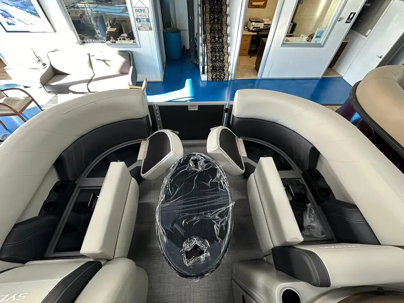 Slide: The Image of 2025 Sylvan Mirage 8520 CLZ DH pontoon boat interior with plush seating and table. - 15