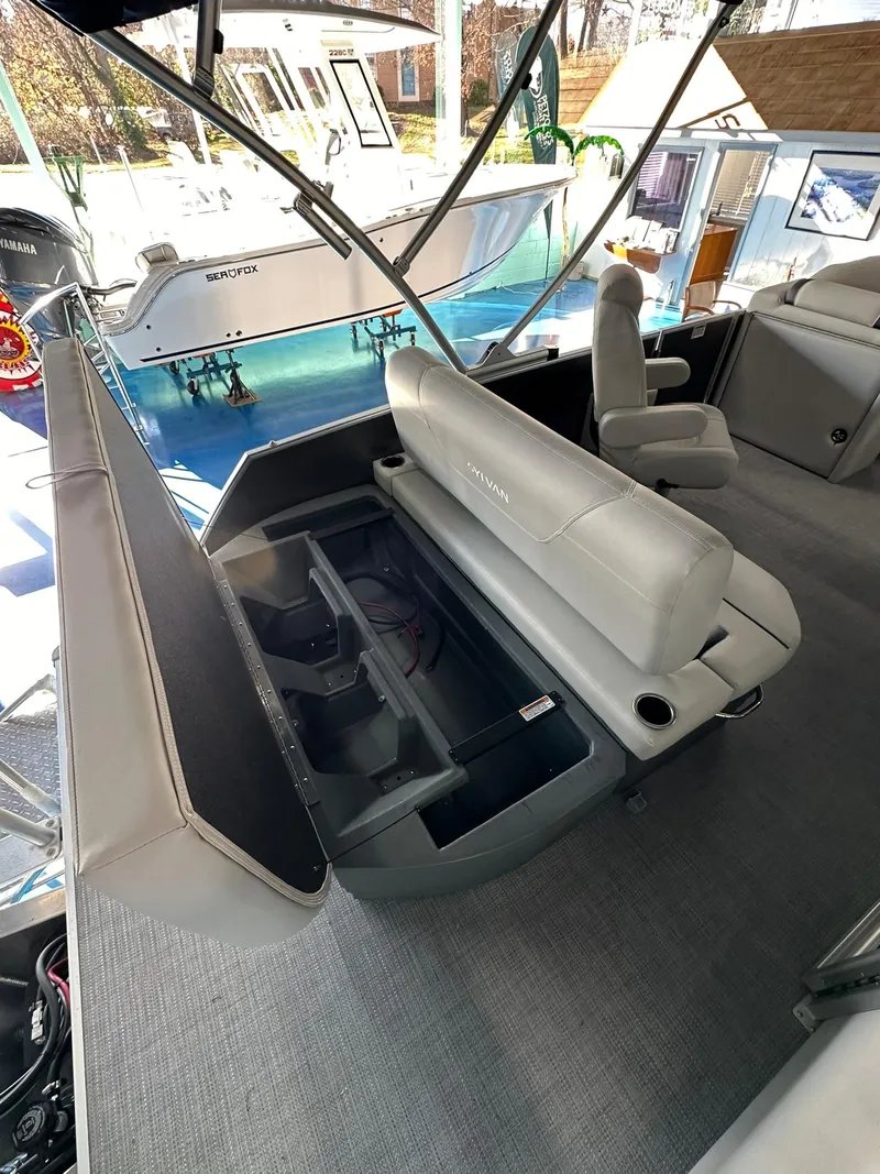 Slide: The Image of 2025 Sylvan Mirage 8520 CLZ DH boat interior with open storage compartment. - 8