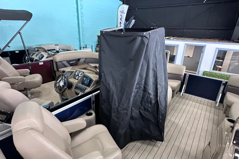 Slide: The Image of 2026 Sylvan Mirage 8522 LZ pontoon boat interior with beige seating and black privacy curtain. - 18