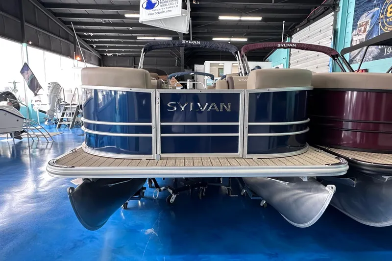 Slide: The Image of 2026 Sylvan Mirage 8522 LZ pontoon boat displayed in a showroom. - 2
