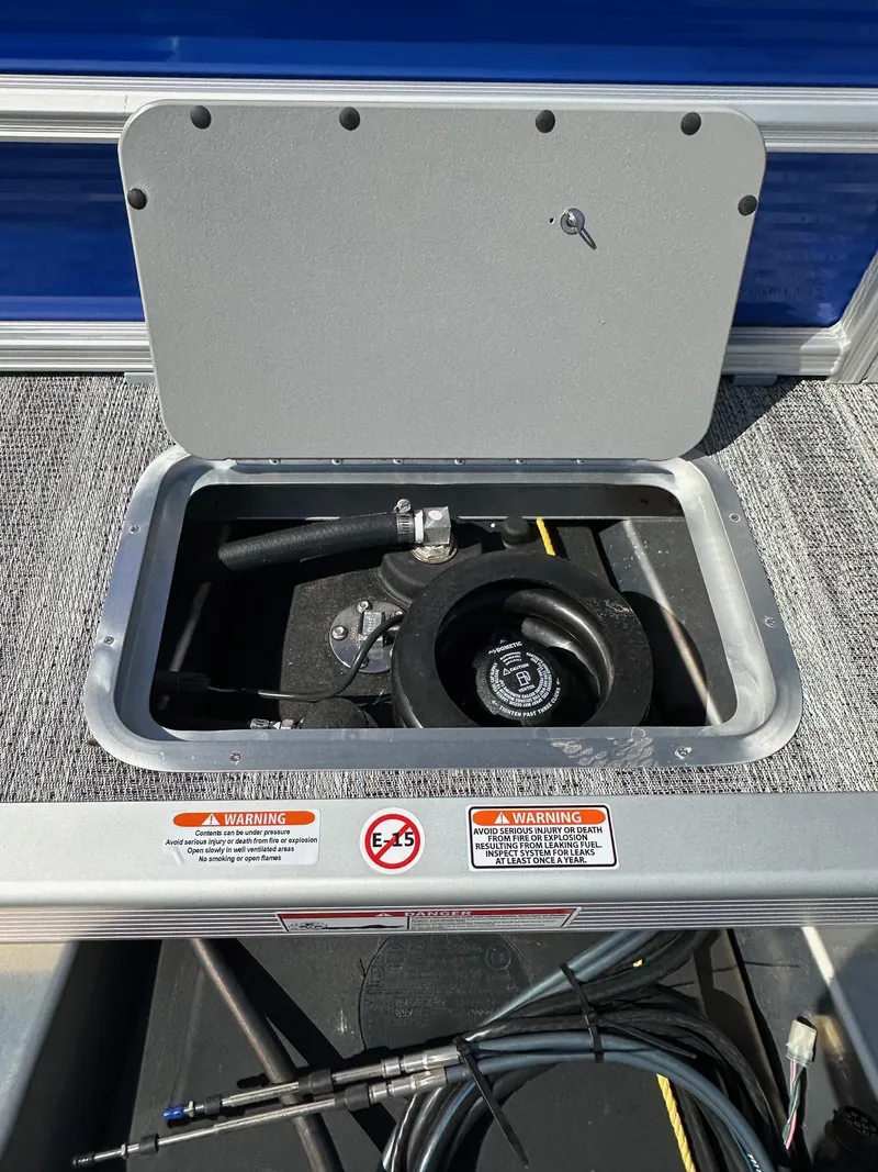 Slide: The Image of Open storage compartment on 2025 Bennington 168 SL boat, showing equipment and warning labels. - 10