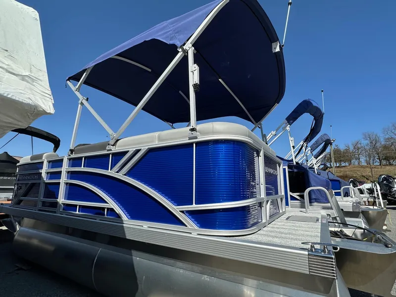 Slide: The Image of 2025 Bennington 168 SL pontoon boat with blue canopy and sleek design, in stock. - 11