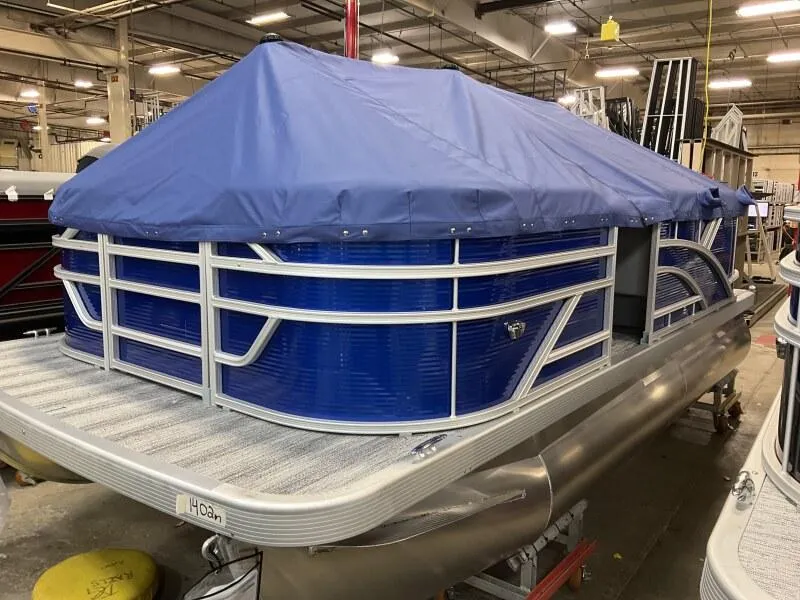 Slide: The Image of 2025 Bennington 168 SL pontoon boat with blue cover in warehouse. - 15