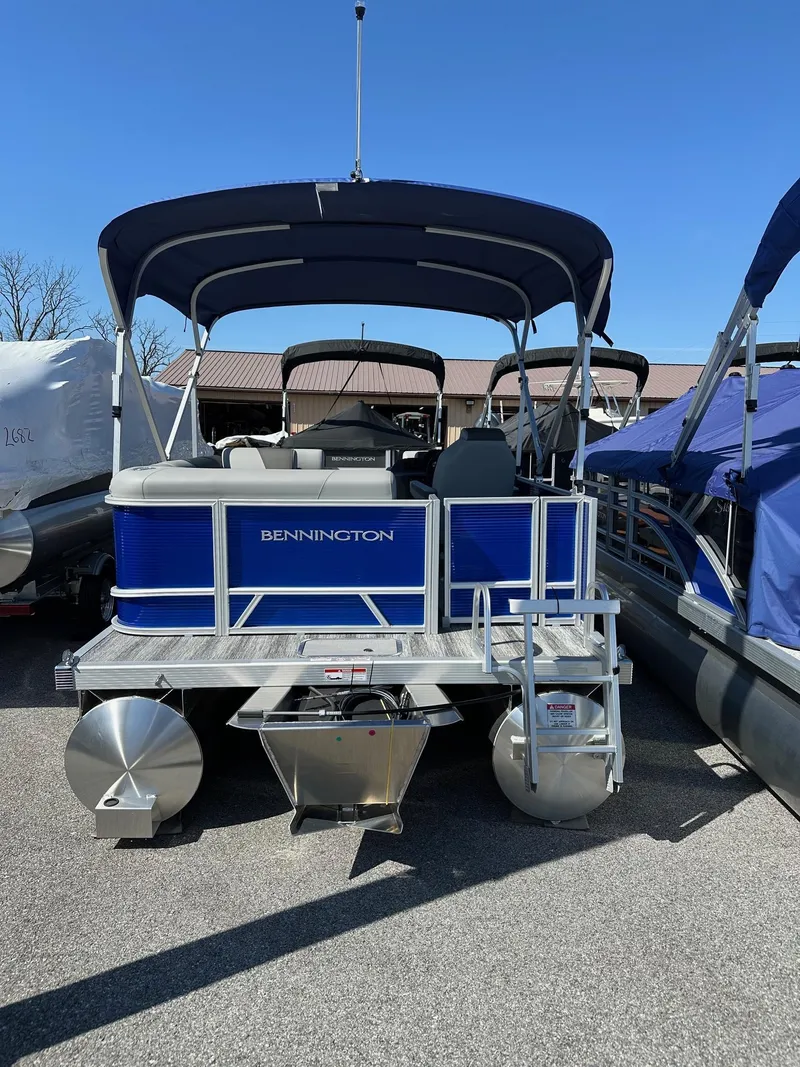 Slide: The Image of 2025 Bennington 168 SL pontoon boat in stock, blue exterior, parked outdoors. - 22