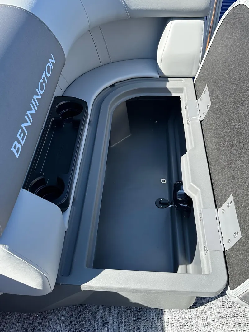 Slide: The Image of 2025 Bennington 168 SL boat storage compartment with open lid and cup holders. - 25
