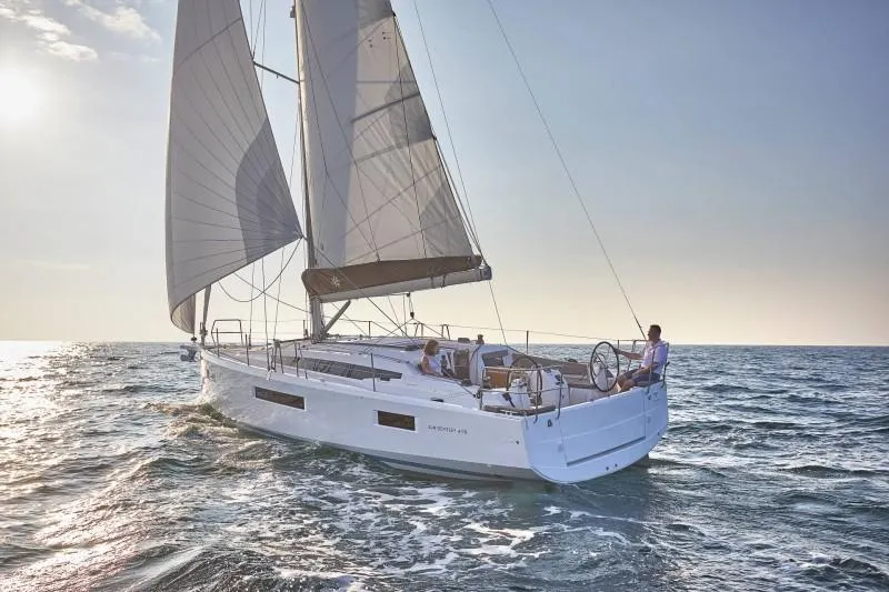 Slide: The Image of 2024 Jeanneau Sun Odyssey 410 sailing on open sea under clear skies. - 2