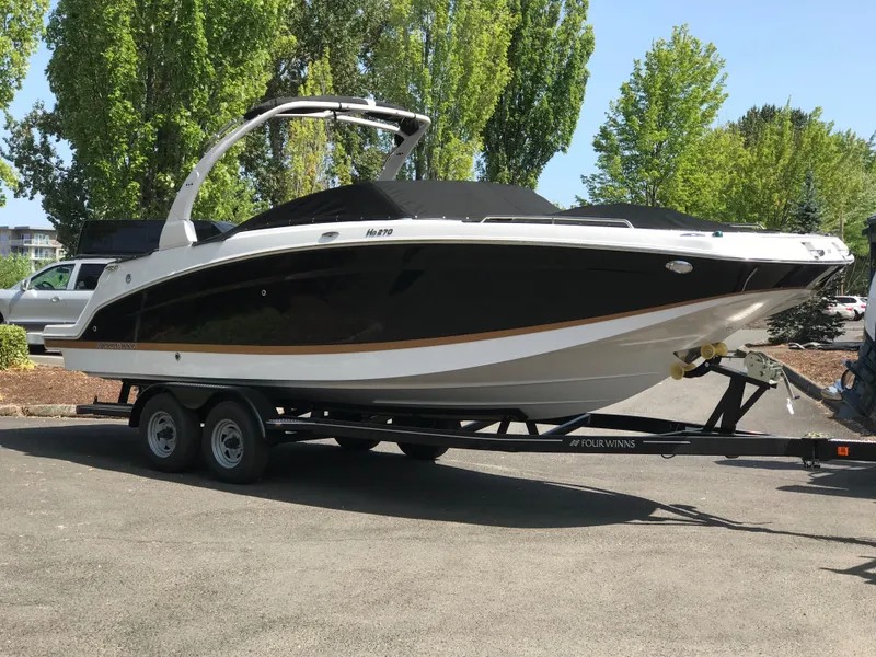 Slide: The Image of 2019 Four Winns HD270 boat parked on trailer outdoors. - 2