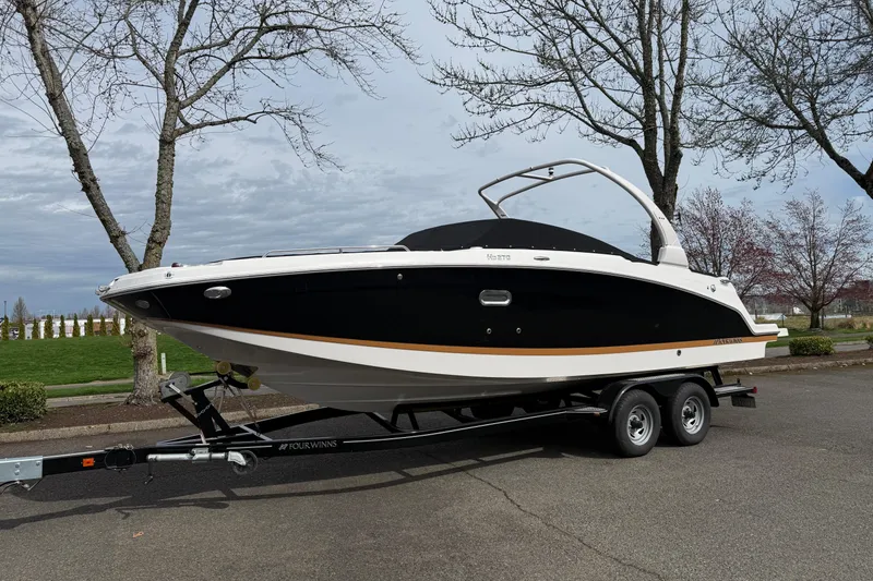 Slide: The Image of 2019 Four Winns HD270 boat on trailer, parked outdoors under cloudy sky. - 43