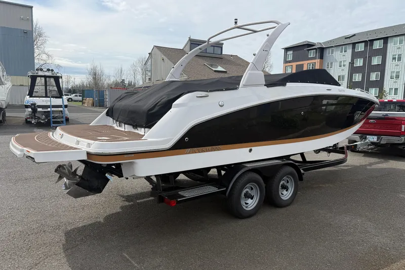 Slide: The Image of 2019 Four Winns HD270 boat on trailer, parked outdoors near buildings. - 46
