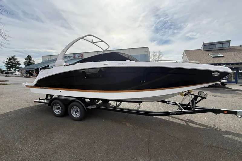 Slide: The Image of 2019 Four Winns HD270 boat on trailer, black and white exterior, parked outdoors. - 47