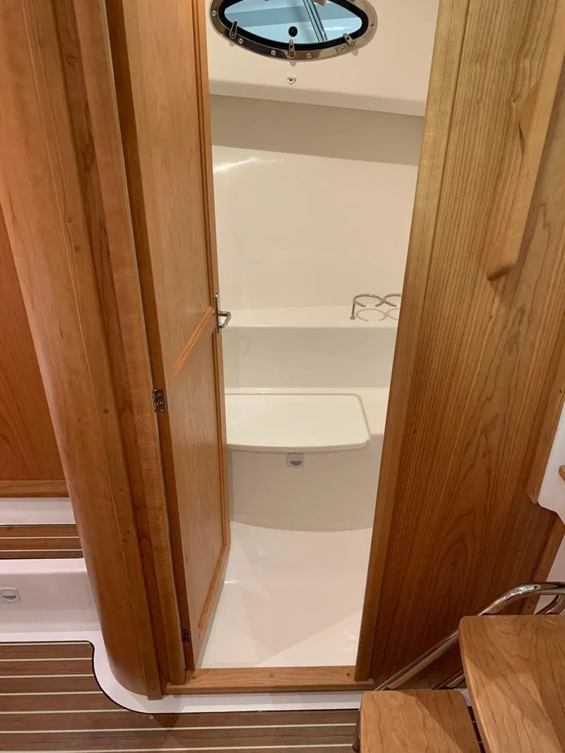 Slide: The Image of Interior view of 2027 Back Cove 34O Hardtop Express, featuring wooden door and compact bathroom. - 13