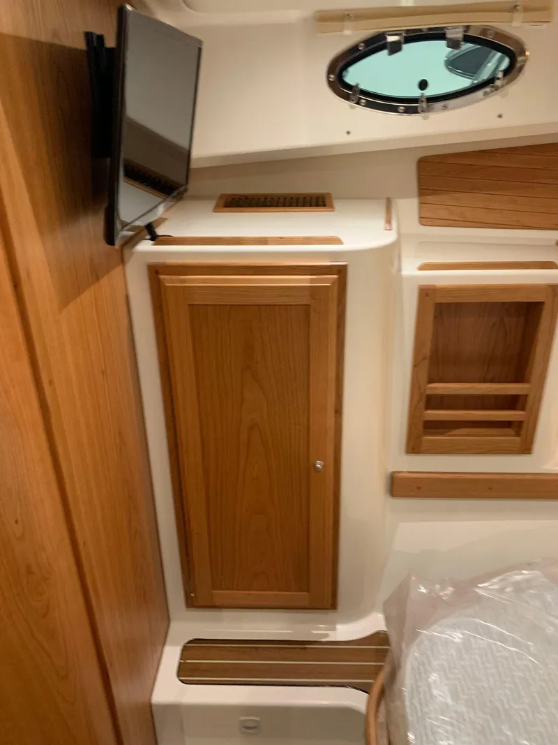 Slide: The Image of Interior of 2027 Back Cove 34O Hardtop Express with wood cabinetry and porthole window. - 16