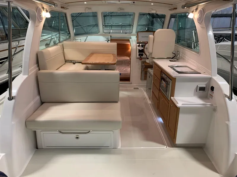 Slide: The Image of Interior of 2027 Back Cove 34O Hardtop Express, featuring seating, table, and kitchenette. - 3