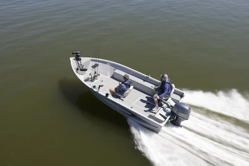 Slide: The Image of 2023 Smoker Craft Freedom 16 tiller deep V boat on water, two people onboard. - 10